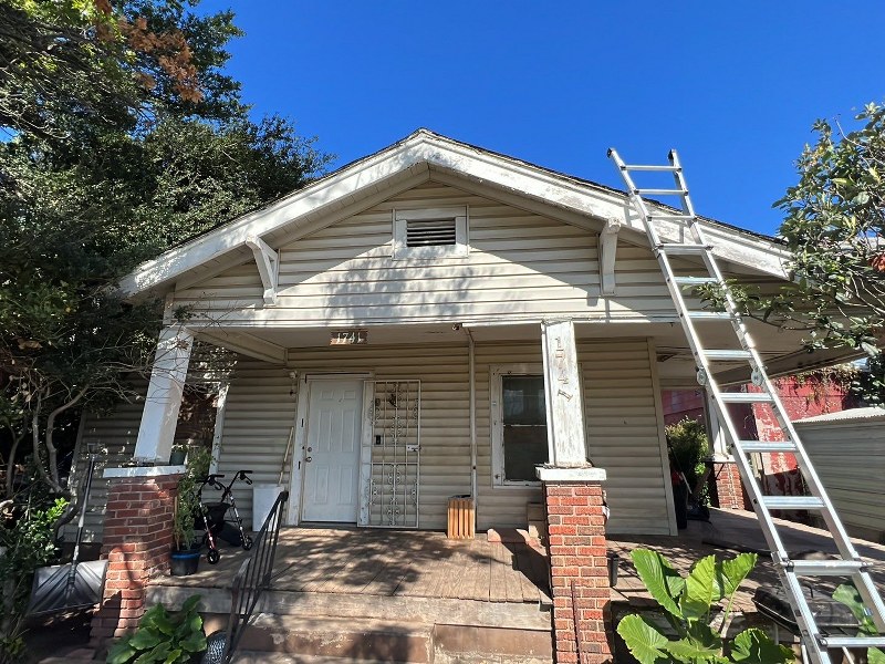 Front of a home with a ladder leaning on the roof