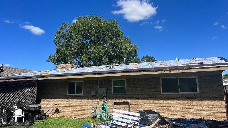 House with new shingles being installed